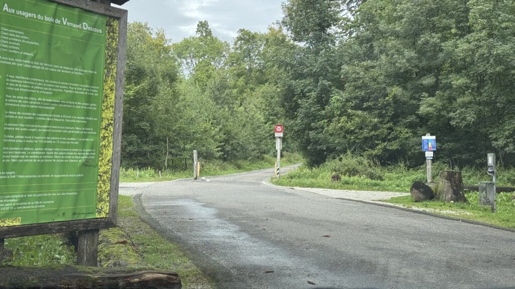 Entrée du bois de Vernand-Dessous avec panneau d'accueil.