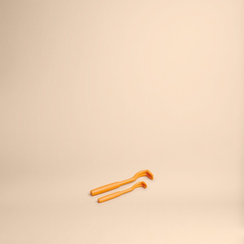 Deux tire tiques orange sur fond beige